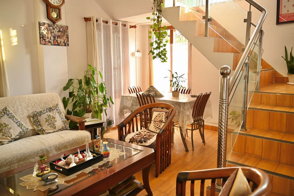 Beautiful living room interior with wooden furniture and lush indoor plants, creating a warm and inviting atmosphere.