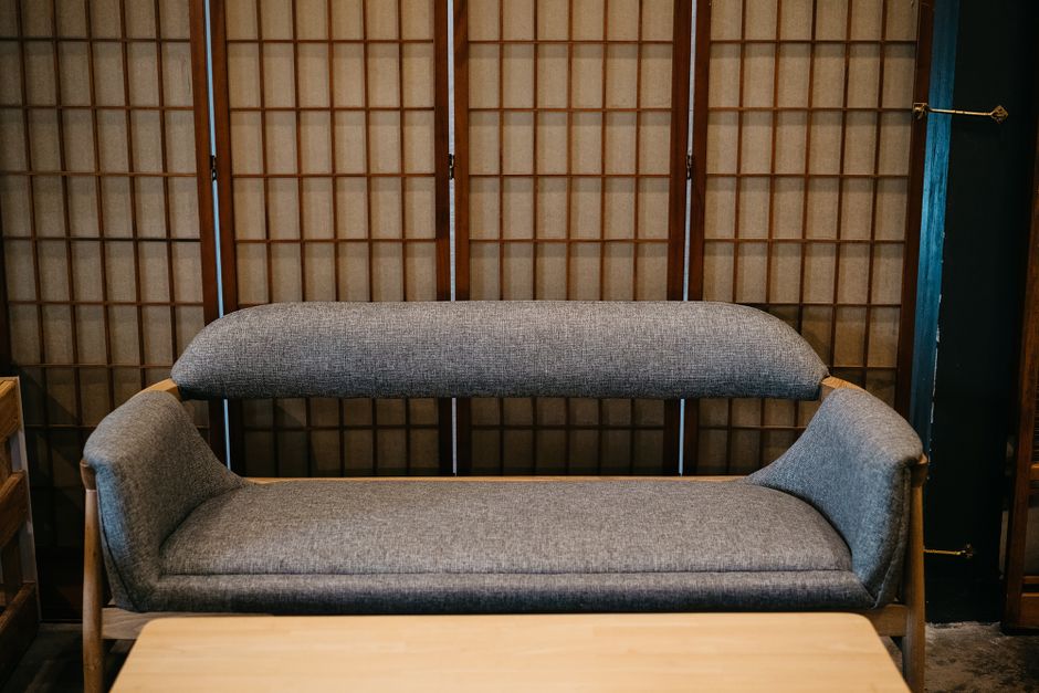 Elegant minimalist sofa with Japanese shoji screen backdrop creating a tranquil modern interior.